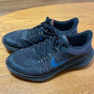 Black and blue pair of Nike running shoes